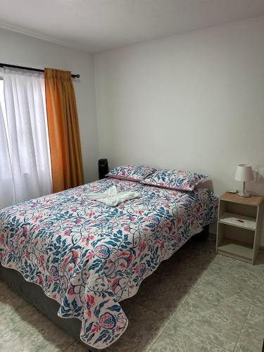 a bedroom with a bed with a colorful comforter at ApartahotelVacacionalSangil in San Gil