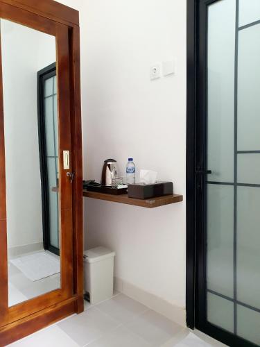 a bathroom with a mirror and a toilet at GYANA House in Ubud