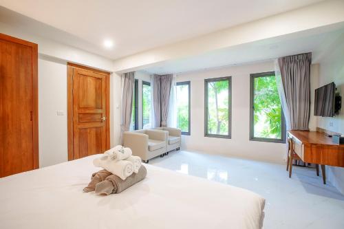 A103 Banjong 1 Bed apart, Near Nai Harn Beach في Ban Saiyuan (1): غرفة نوم بيضاء مع سرير ومكتب وكرسي