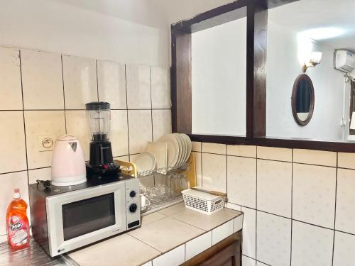 a kitchen with a blender on top of a microwave at Yaoundé Daniella house in Yaoundé