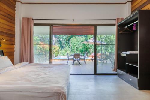 a bedroom with a bed and a patio with a table at Villa Primor madawan Koh Phangan in Wok Tum