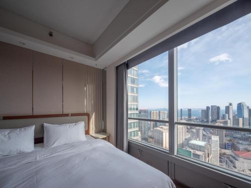 Postel nebo postele na pokoji v ubytování Dalian Zhongshan Square Seaview Meilun Hotel