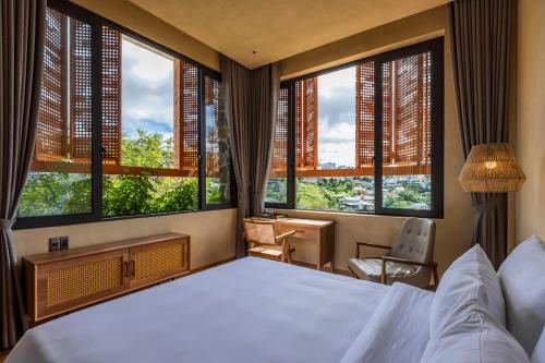 Ấp Ða LợiにあるLà Yên Retreatの大きなベッドと大きな窓のある寝室