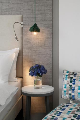 a table with a vase of blue flowers on it in a bedroom at Hotel Metropol in Warsaw
