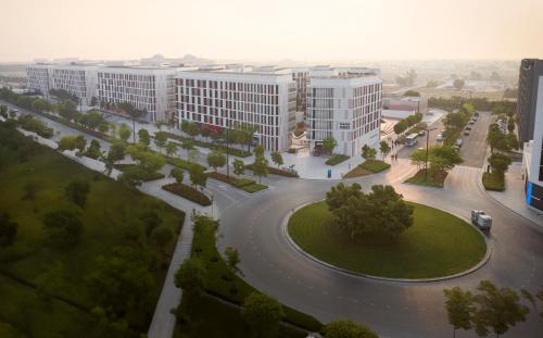 an aerial view of a large building with a park at Nest Hotel, Aljada in Sharjah