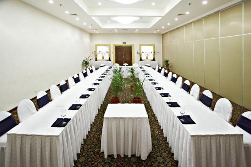 a long table with white tables and chairs in a room at Barceló Ixtapa - All Inclusive in Ixtapa