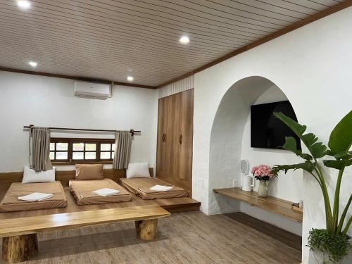 a living room with two beds and a tv at Lalagigi Homestay in La Gi