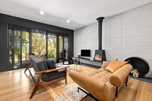 a living room with a couch and a fireplace at Romantic Lakefront Luxury - Spa Bath, Fireplace, King Bed in Daylesford
