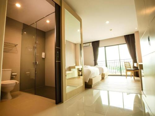 a bathroom with a shower and a bed and a toilet at L Hotel in Ban Si Than