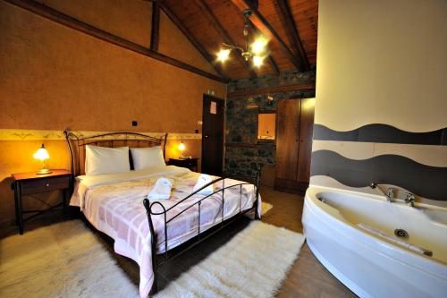a bedroom with a bed and a bath tub at Guesthouse Nifada tou Vorra in Palaios Agios Athanasios
