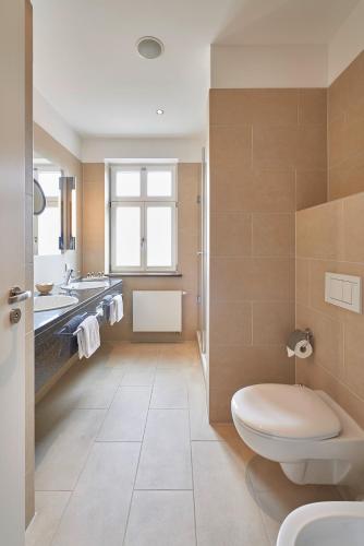 a bathroom with a toilet and a sink at Hotel Elbresidenz an der Therme in Bad Schandau