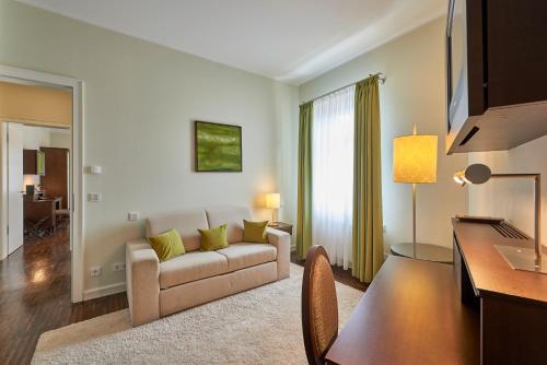a living room with a couch and a table at Hotel Elbresidenz an der Therme in Bad Schandau
