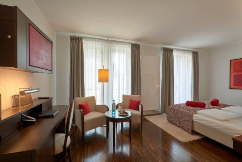 a hotel room with a bed and a table and chairs at Hotel Elbresidenz an der Therme in Bad Schandau