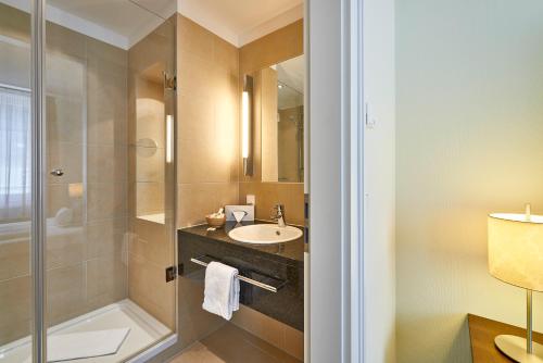a bathroom with a sink and a shower at Hotel Elbresidenz an der Therme in Bad Schandau