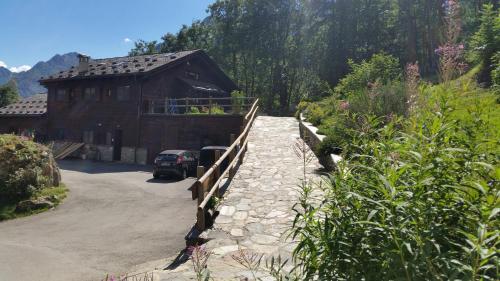a house with a fence next to a driveway at Agriturismo Alagna in Alagna Valsesia