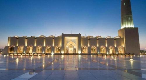 a large building with a clock tower in front of it at Sovereign Hotel - Marriage Certificate Required in Doha