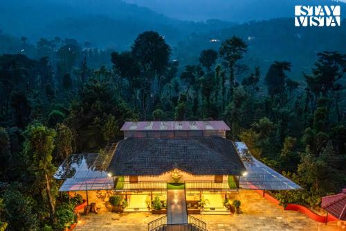une vue aérienne d'une maison dans la forêt dans l'établissement StayVista at Hermitage 4BR - Boutique Stay - Relax in Nature, à Irpu