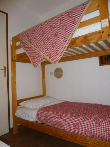 a bedroom with a bunk bed with a red and white blanket at Résidence Azureva La Clusaz les Aravis in La Clusaz