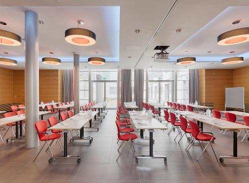 a dining room with tables and red chairs at Hotel Elbresidenz an der Therme in Bad Schandau