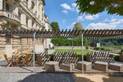 a patio with two chairs and a pergola at Hotel Elbresidenz an der Therme in Bad Schandau