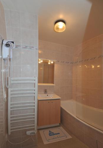 a bathroom with a shower and a sink and a tub at Résidence Azureva Les Menuires in Les Menuires