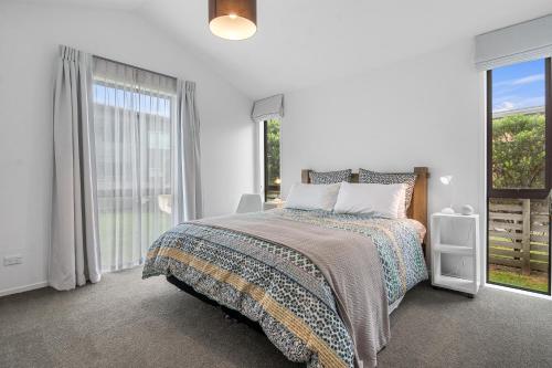 a white bedroom with a bed and a large window at White Sands Haven - Omaha Family Escape in Omaha