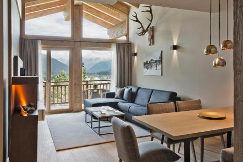 a living room with a couch and a table and a fireplace at Natur & Spa Hotel Lärchenhof in Seefeld in Tirol