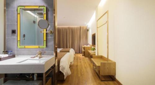 a bathroom with a sink and a mirror at James Joyce Coffetel Qufu Tourist Center Gulou Street Sankong Scenic Spot in Qufu