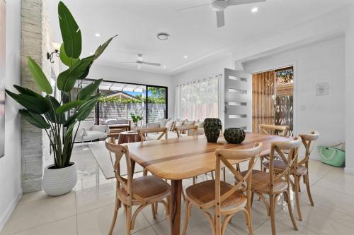 a dining room with a wooden table and chairs at Palm Beach Retreat: Plunge Pool & Coastal Luxe in Gold Coast
