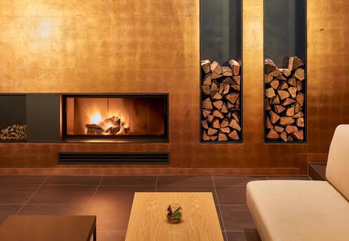a living room with a fireplace and a table at Hotel Elbresidenz an der Therme in Bad Schandau