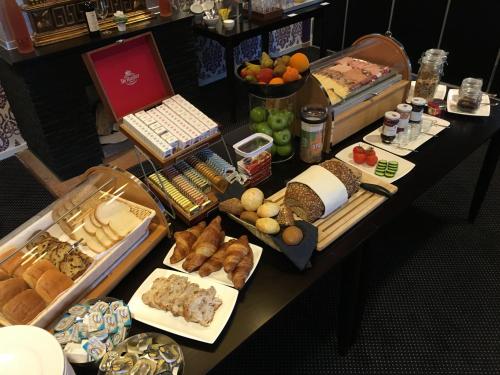 a table filled with different types of bread and pastries at Hotel Faber in Hoogezand