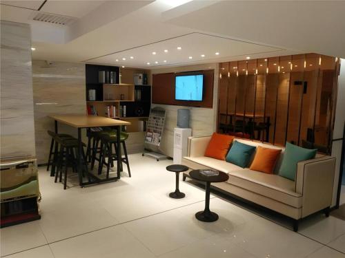 a living room with a couch and a table at City Comfort Inn Yanji Yanbian University Department Building in Yanji