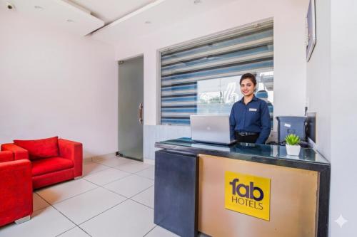 a woman standing at a desk with a laptop at FabHotel Gazelle Studios in Gurgaon