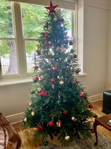a christmas tree with ornaments on it in a room at Executive Cottage, Luxe 1930s Stay in the Heart in Albury