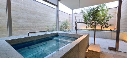 a swimming pool in a house with a large window at 住 京都小川生薬 VILLA Jyu KyotoOgawaSyouyaku VILLA in Kyoto