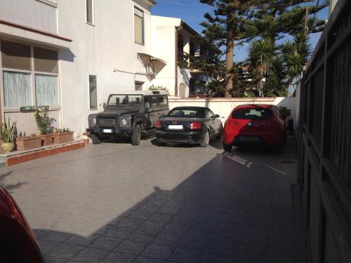 two cars parked in a parking lot next to a building at B&B San Leone in San Leone