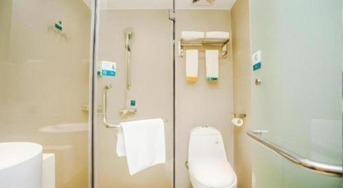 a bathroom with a toilet and a glass shower at City Comfort Inn Shenzhen Shiyan Science and Technology Park in Xin'an