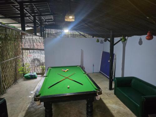 eine Tischtennisplatte in einem Zimmer mit einer Couch in der Unterkunft Lunar Park in Phumĭ Ta Phŭl