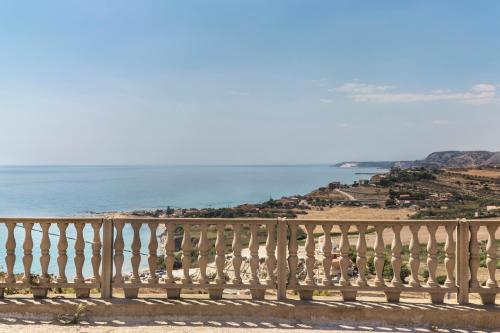 a wooden bench sitting on a balcony overlooking the ocean at B&B Monterosso in Realmonte