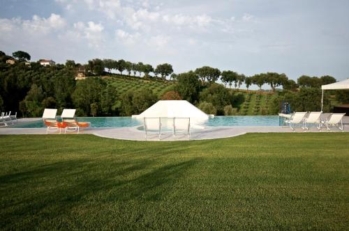 a white tent in a field next to a swimming pool at Moresco Agriturismo in Moresco
