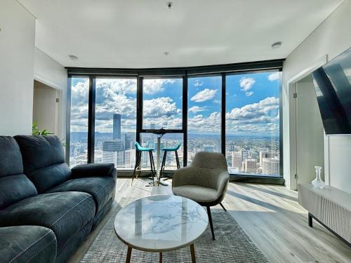 a living room with a couch and a large window at Brisbane Skytower -61st Floor- 3Bed 2Bath Luxury Apartment & FREE welcome pack in Brisbane