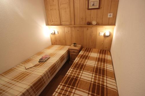 Cette petite chambre comprend 2 lits et des toilettes. dans l'établissement Beausoleil Appartements VTI, à Val Thorens