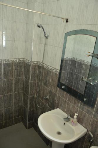 a bathroom with a sink and a shower with a mirror at Happy Tuna Beach Apartment in Hikkaduwa