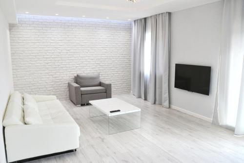 a white living room with a white couch and a chair at Bad Ischl - Central & Quiet Apartment in Bad Ischl