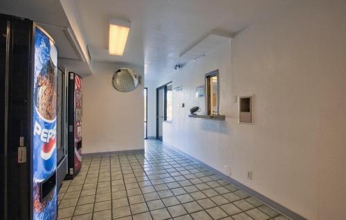 a hallway with a tile floor and white walls at Motel 6-Valdosta, GA - University in Valdosta