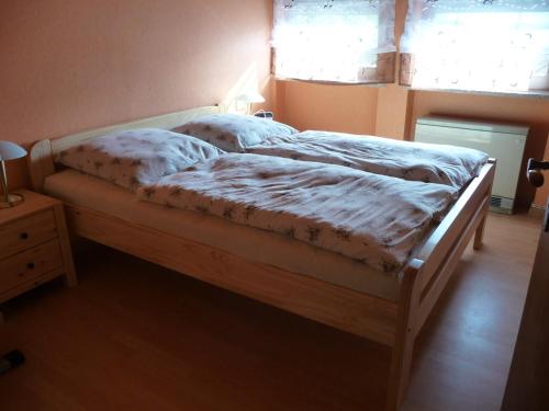 ein Schlafzimmer mit einem Bett mit einem Holzrahmen in der Unterkunft Ferienwohnung Bruni in Birresborn