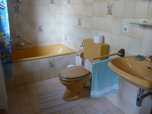 een badkamer met een toilet, een wastafel en een bad bij Ferienwohnung Bruni in Birresborn
