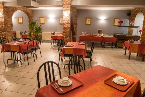 een eetkamer met tafels en stoelen en een restaurant bij LOGIS Hôtel - Les Paturelles in Avesnelles