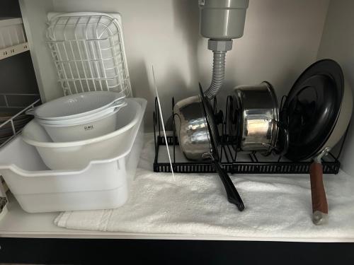 Un mostrador de cocina con utensilios en un estante. en とっくりhouse, en Takashima