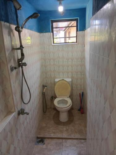 um banheiro com vaso sanitário e chuveiro em Amaya Hostel and Restaurant em Batigama